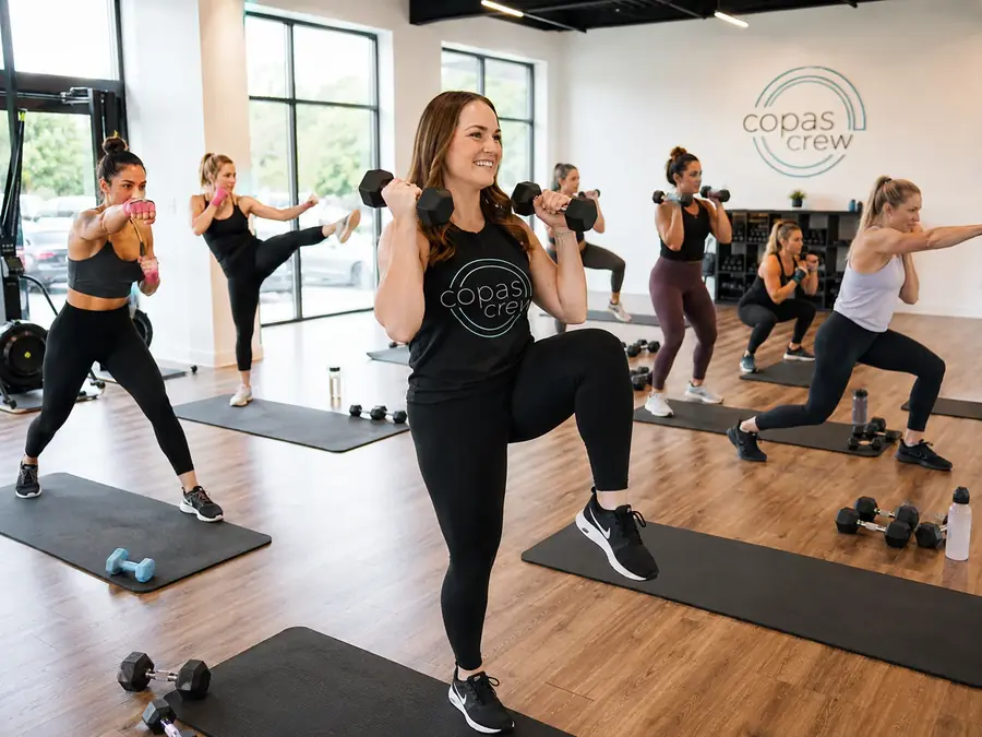 Kick & Sculpt class at Copas Crew Fitness — dumbbell presses and kicks in the same round